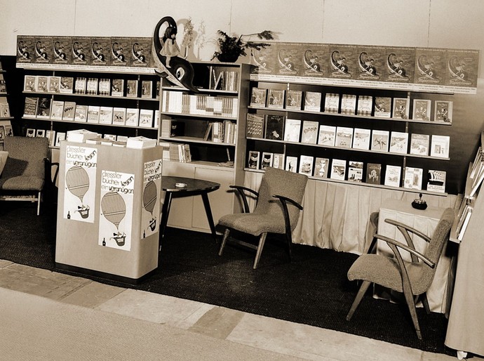 Der Stand des Cecilie Dressler Verlags auf der Buchmesse 1964. Ausgestellte Bücher und Sessel laden zum Schmökern und Verweilen ein.